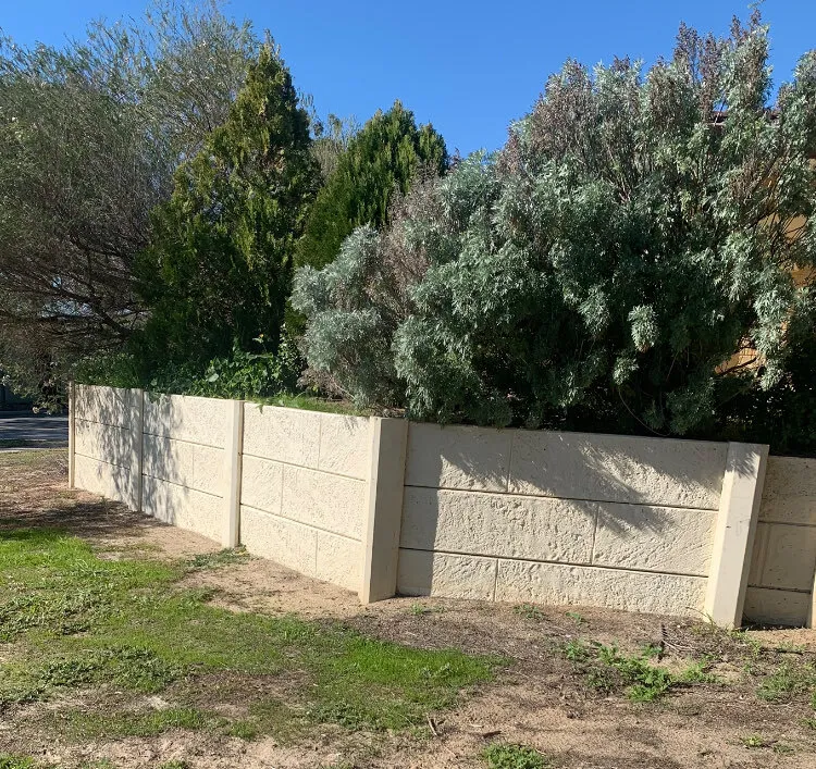 Low limestone-look panel retaining wall along a Perth front garden